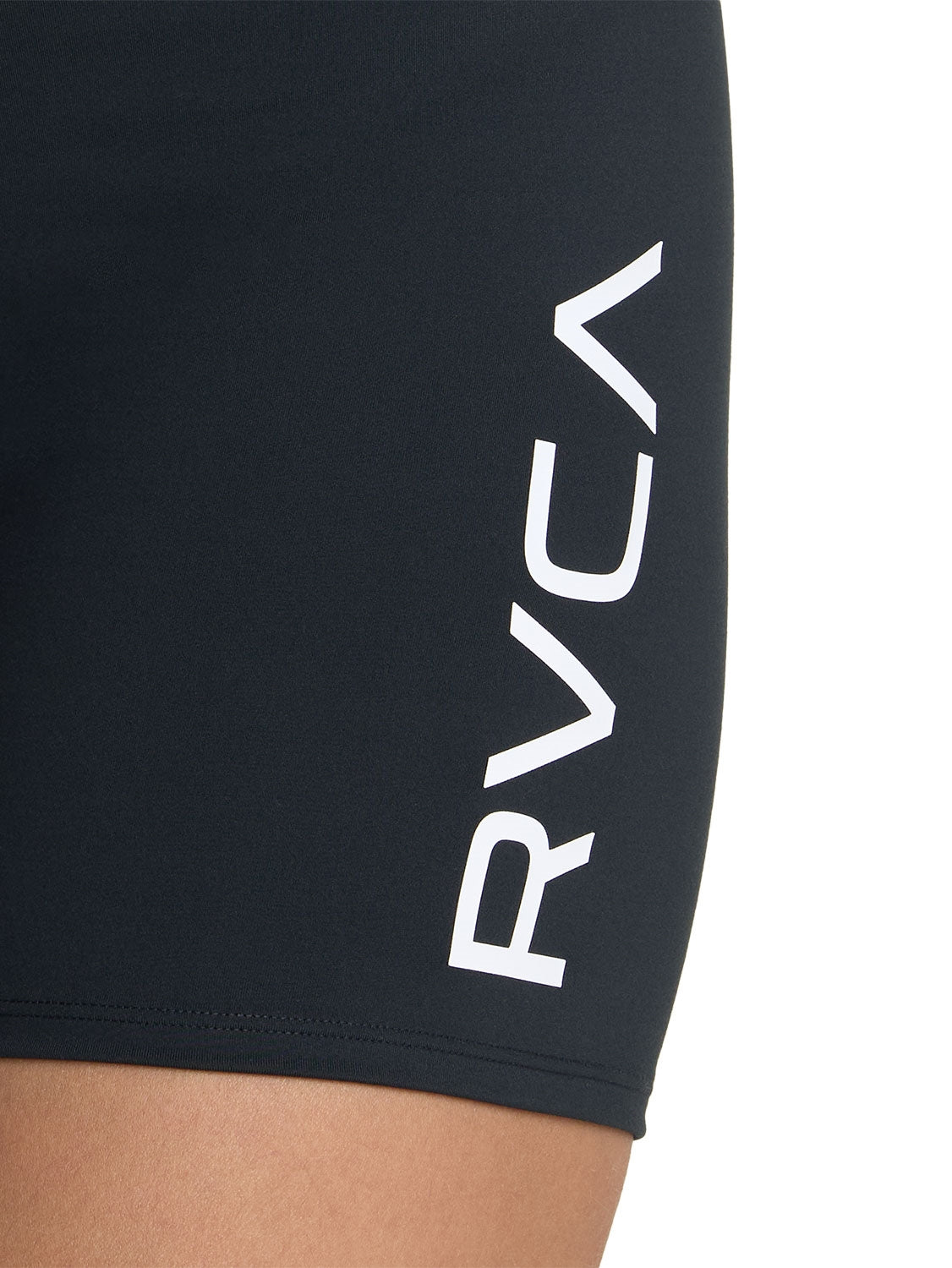 Black athletic biker shorts with a white 'VA' logo on the lower left leg. Close Up Logo View
