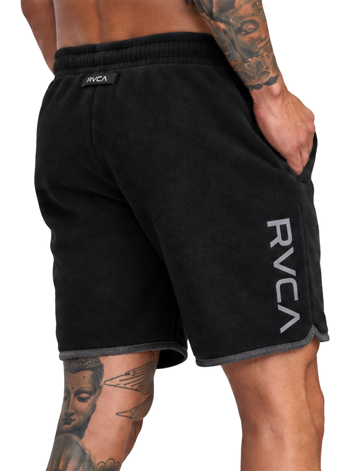 Black athletic shorts with a gray ribbed hem, featuring a vertical white RVCA logo on the left leg and a small black brand tab at the waistband. Back Angled View