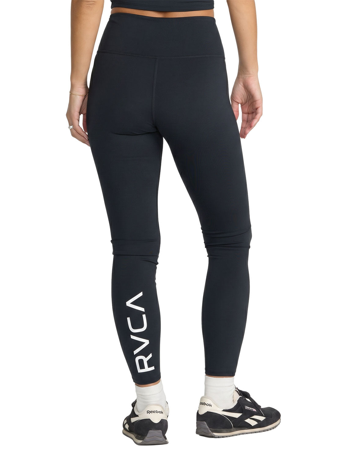 Black high-waisted athletic leggings with a large white vertical RVCA logo on the lower left leg. Back View