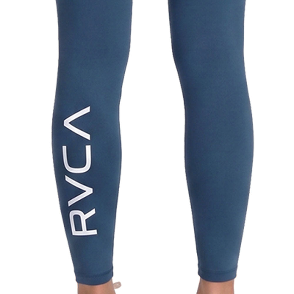 Blue high-waisted athletic leggings with a large white vertical RVCA logo on the lower left leg. Back Close Up View