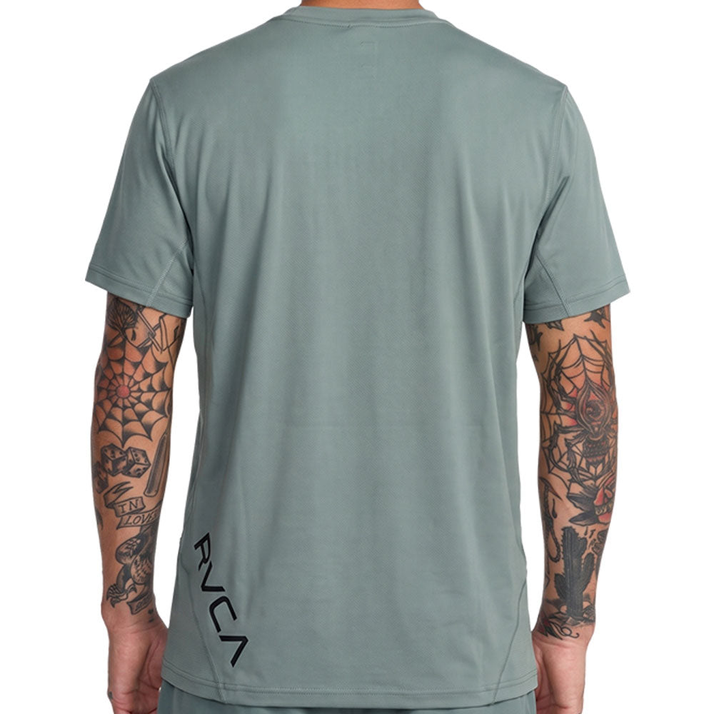 Green athletic t-shirt with a black vertical 'RVCA' logo printed on the lower back. Back Close Up View