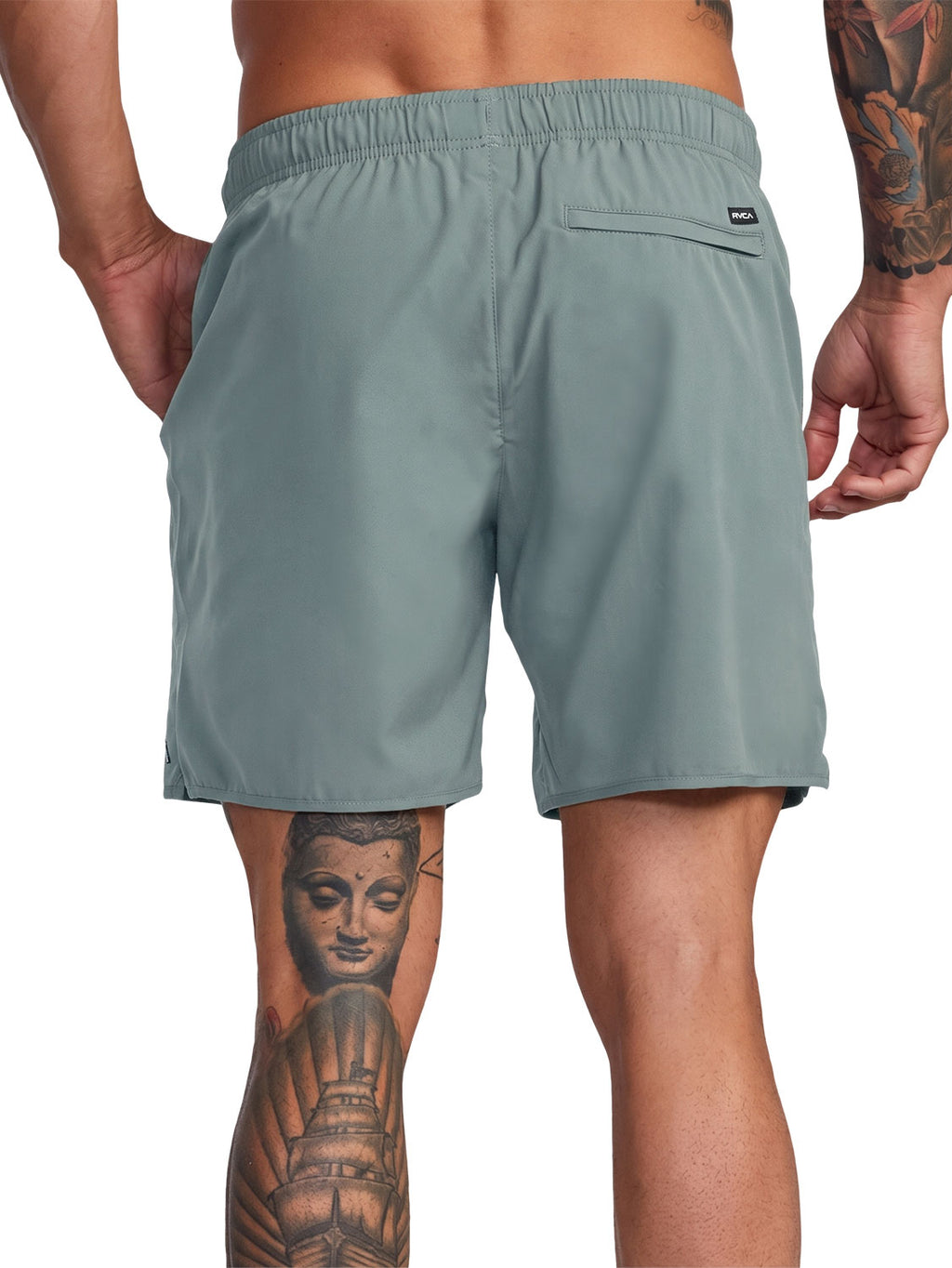 Green athletic shorts with a small black logo patch on the back pocket. Back View.
