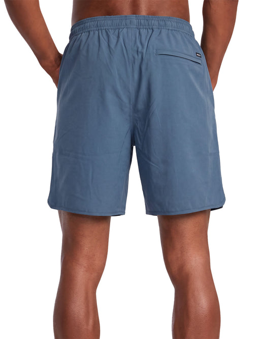 Blue athletic shorts with a small black logo patch on the back pocket. Back View.
